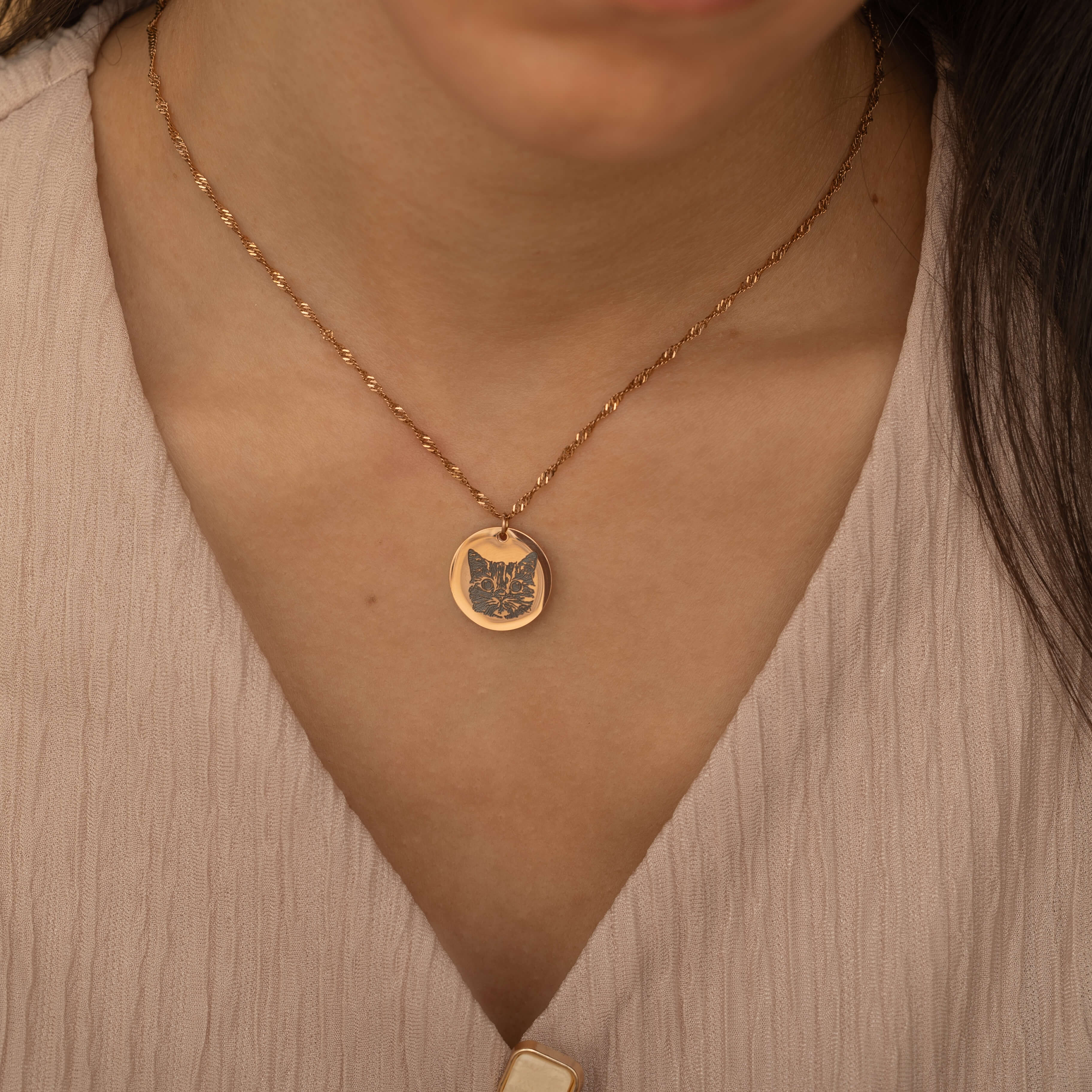 Rose Gold pendant necklace featuring an engraved portrait of a cat worn by a woman