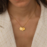 Gold necklace with multiple charms, each engraved with different US state outlines and personalized message, worn by a woman.