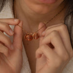 Rose Gold necklace with multiple charms, each engraved with different US state outlines and personalized message, worn by a woman.