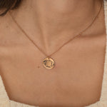 Rose Gold pendant necklace featuring an engraved outline of dog ears with a pet's name underneath, worn by a woman.