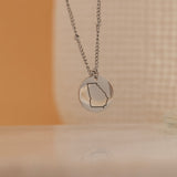 Silver necklace of a US State outline hanging 