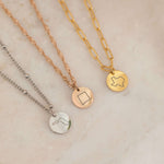 Close up of three necklace with US states outlines in gold, silver and rose gold 