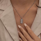 Silver the wheel tarot necklace with cubic zirconia accents and a mother of pearl back stone, symbolizing change, destiny, and the cycles of life. 