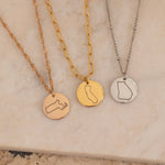 Three Necklaces of US states gold, silver and rose gold on top of a stone