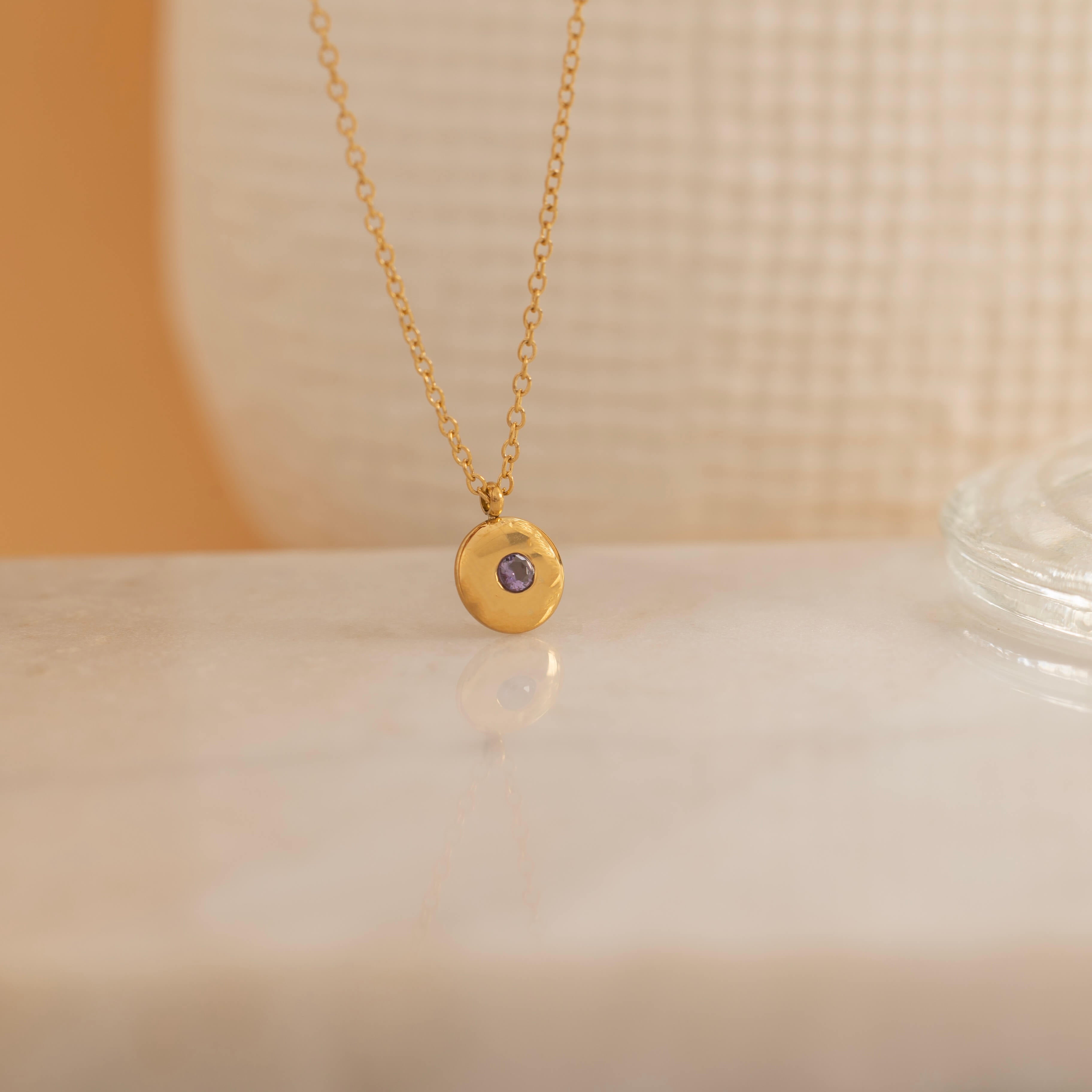 Round birthstone necklace with a polished coin pendant and center-set birthstone, offering personalized elegance and meaning for each birth month