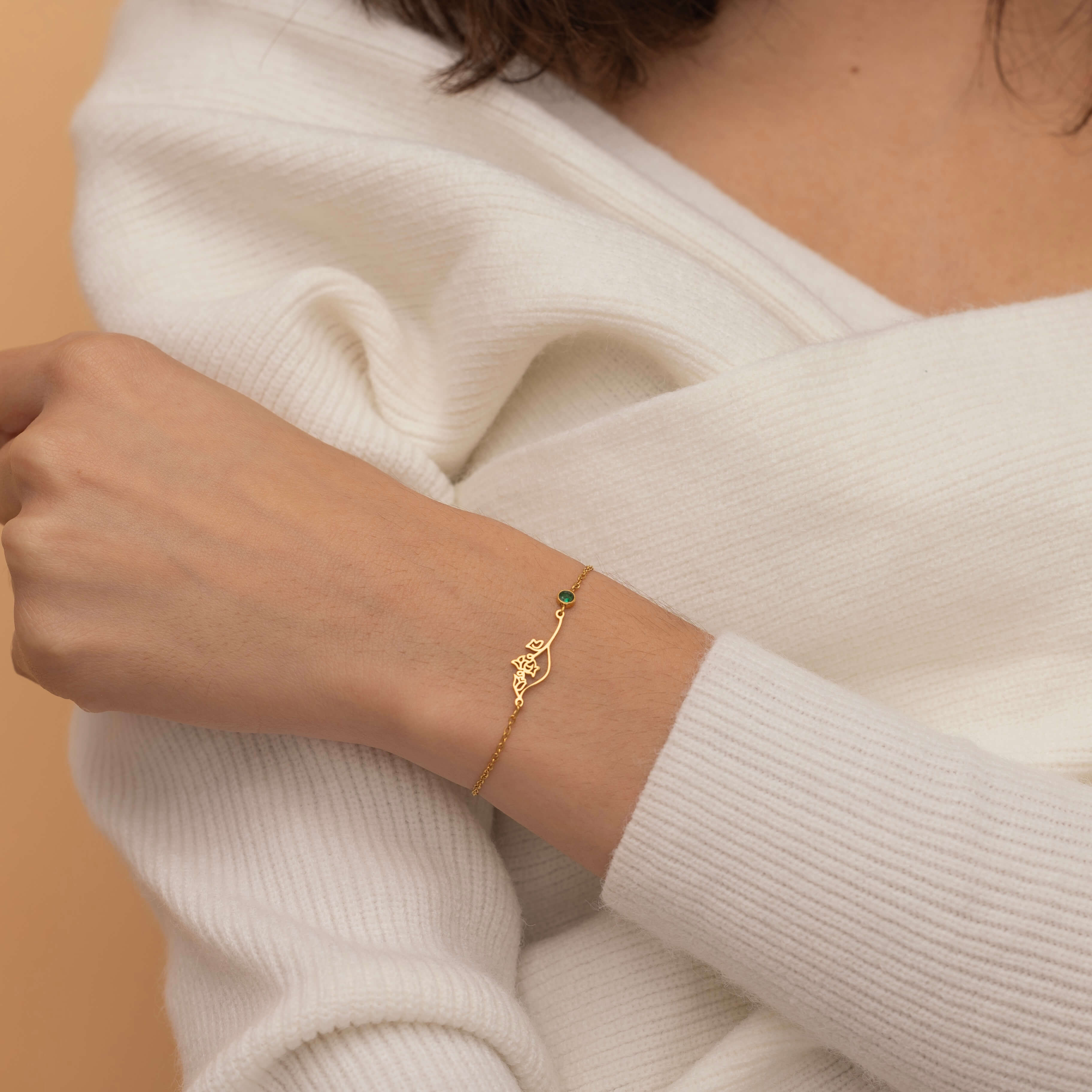 Custom birth flower and birthstone bracelet in gold, silver, and rose gold with floral outline and matching birthstone charm.