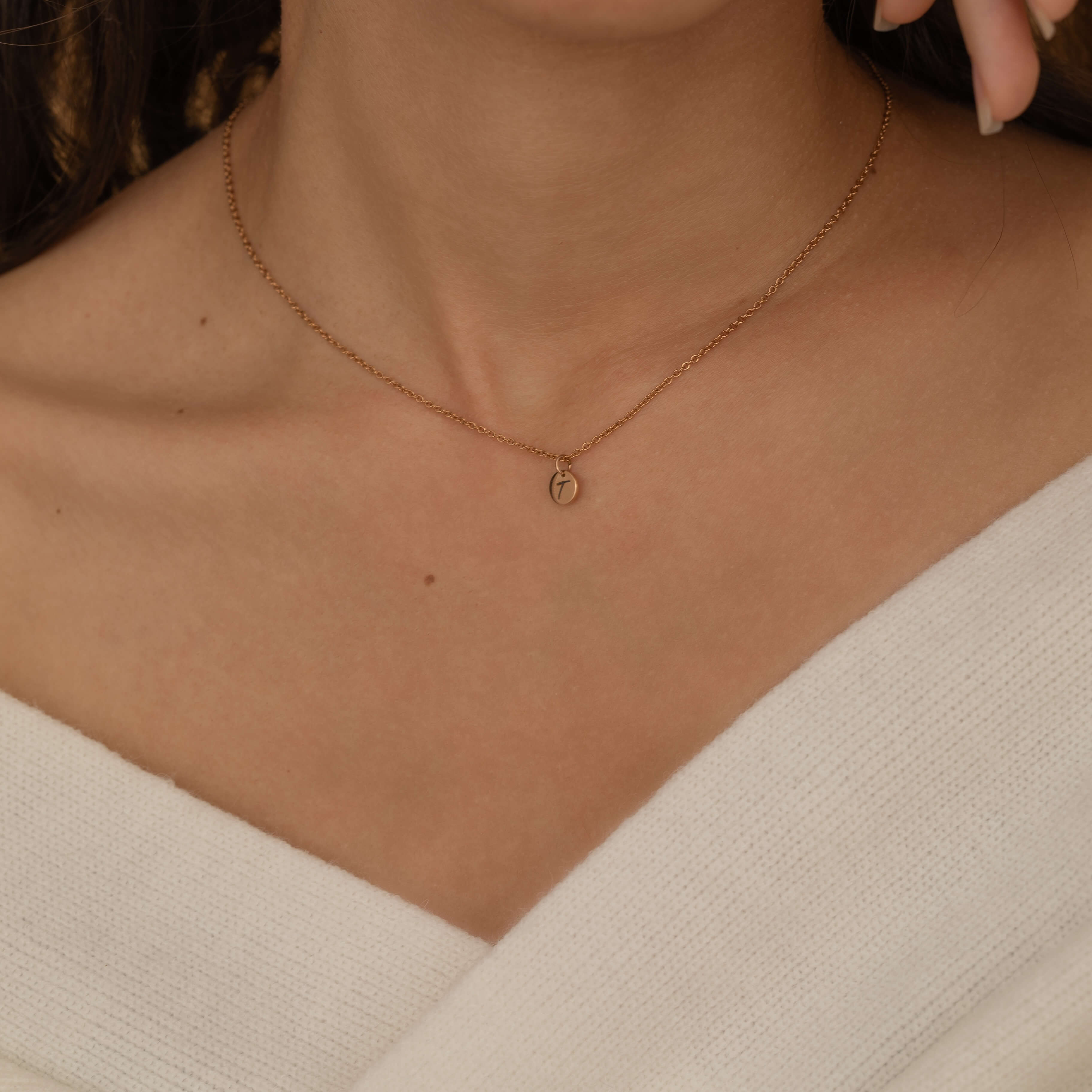 custom initial charm necklaces in gold, silver, and rose gold finishes, each with distinct chain styles and personalized round charms on a marble surface.