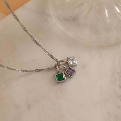 Square birthstone charms in gold and silver frames on a necklace, with multiple colorful birthstone charms representing different birth months