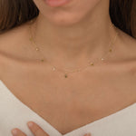 Dainty sterling silver and 14k gold plated necklace featuring four square peridot-colored cubic zirconia stones, one centered teardrop-shaped peridot stone, and four white cubic zirconia accents between the peridot.