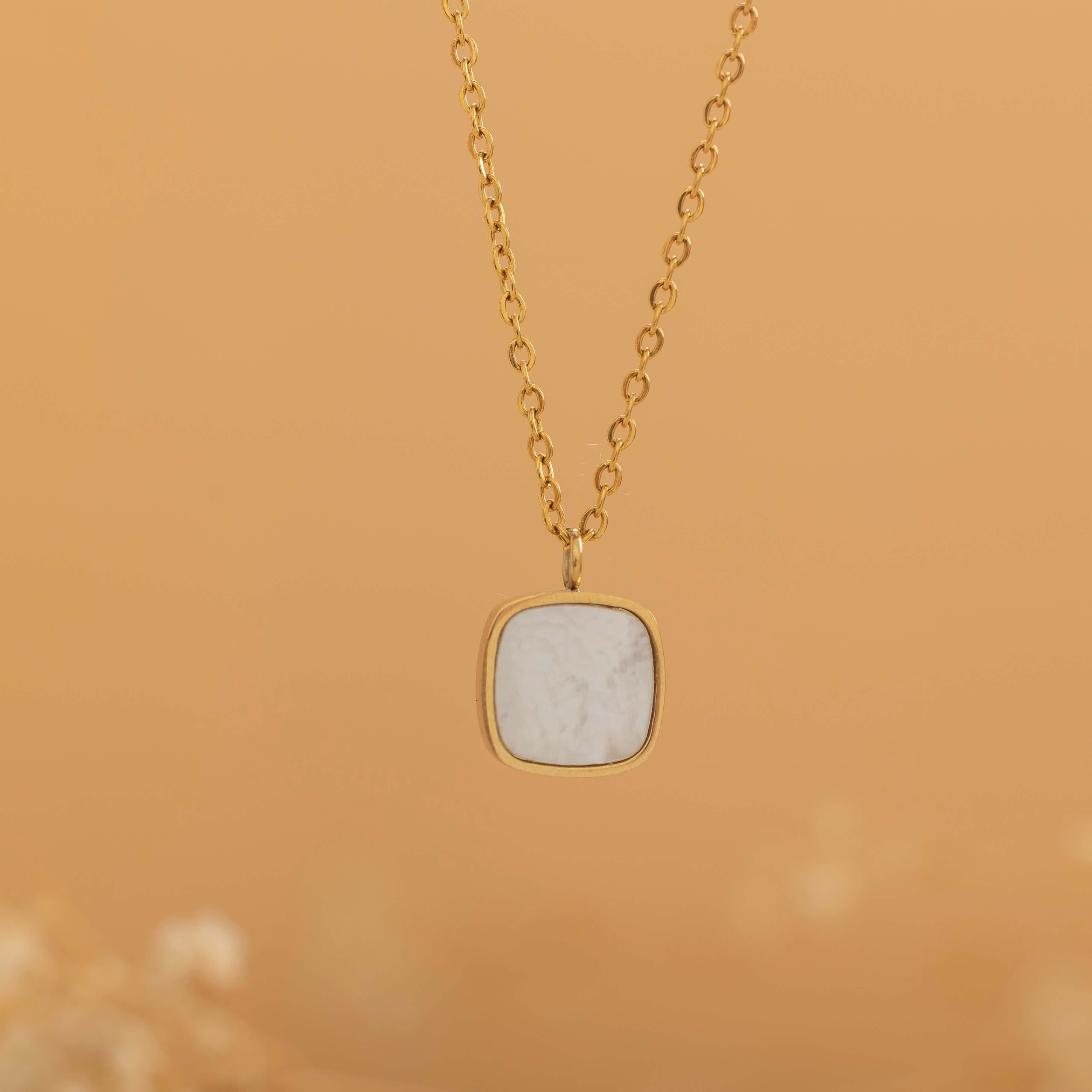 Square mother of pearl pendant with a gold frame on a gold chain