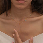 Dainty sterling silver and 14k gold plated necklace featuring four square turquoise birthstone stones, one centered teardrop-shaped turquoise stone, and four white cubic zirconia accents between the turquoise stones. Perfect for mother’s day and prom. 