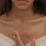 Dainty sterling silver and 14k gold plated necklace featuring four square turquoise birthstone stones, one centered teardrop-shaped turquoise stone, and four white cubic zirconia accents between the turquoise stones. Perfect for mother’s day and prom. 