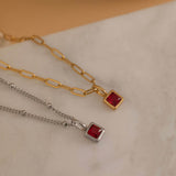 Square birthstone charms in gold and silver frames on a necklace, with multiple colorful birthstone charms representing different birth months