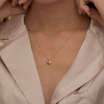 Round birthstone necklace with a polished coin pendant and center-set birthstone, offering personalized elegance and meaning for each birth month