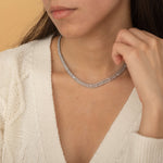 Elegant gold tennis necklace with a continuous row of sparkling, rectangular-cut stones. Perfectly aligned gemstones create a seamless shimmer, adding timeless sophistication to any look. Classic luxury jewelry piece ideal for formal occasions or adding everyday elegance.