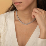 Elegant gold tennis necklace with a continuous row of sparkling, rectangular-cut stones. Perfectly aligned gemstones create a seamless shimmer, adding timeless sophistication to any look. Classic luxury jewelry piece ideal for formal occasions or adding everyday elegance.