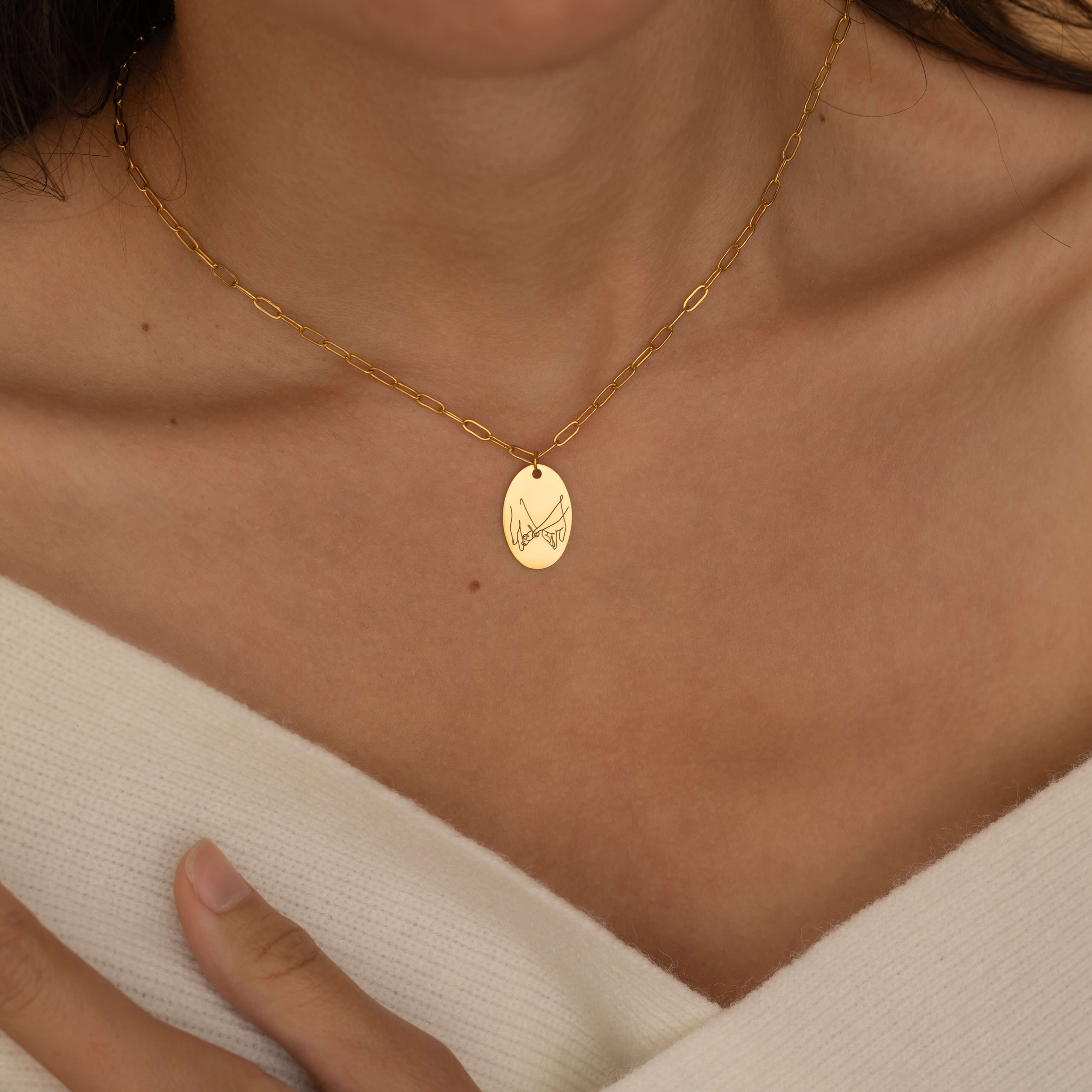 Hand gesture necklace engraving of two hand holding by their little finger worn by a women
