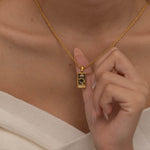 Gold magician tarot necklace with cubic zirconia accents and an onyx back stone, symbolizing the balance of elemental force.
