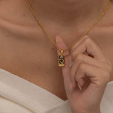 Gold magician tarot necklace with cubic zirconia accents and an onyx back stone, symbolizing the balance of elemental force.