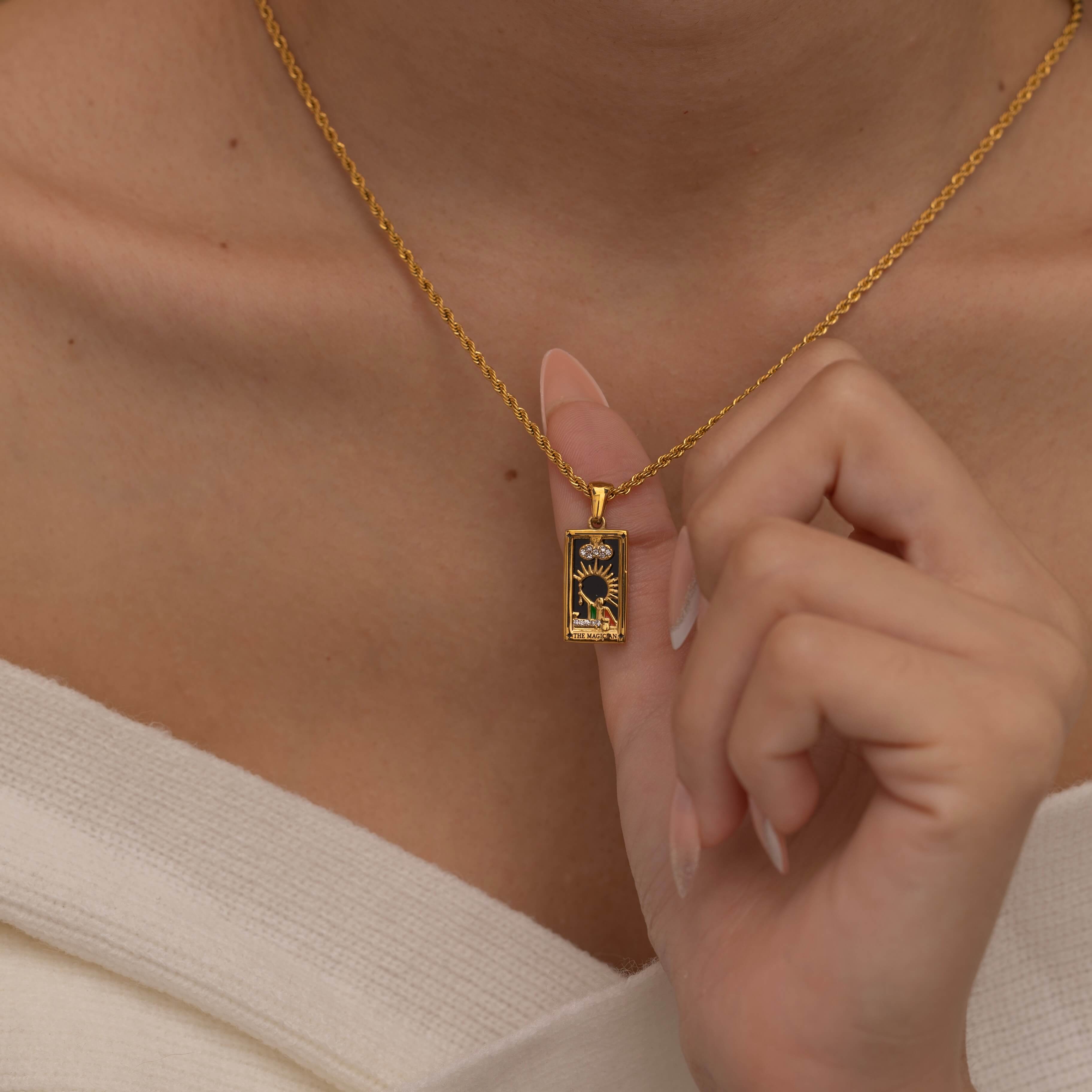 Gold magician tarot necklace with cubic zirconia accents and an onyx back stone, symbolizing the balance of elemental force.