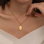 Gold zodiac pendant necklace on a dainty elongated satellite chain, featuring an engraved oval charm available in all zodiac signs for personalized style.
