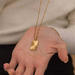 rectangle sunburst necklace with an etched sunburst design on a rectangle pendant, symbolizing warmth and vitality, perfect for adding a touch of boho elegance.