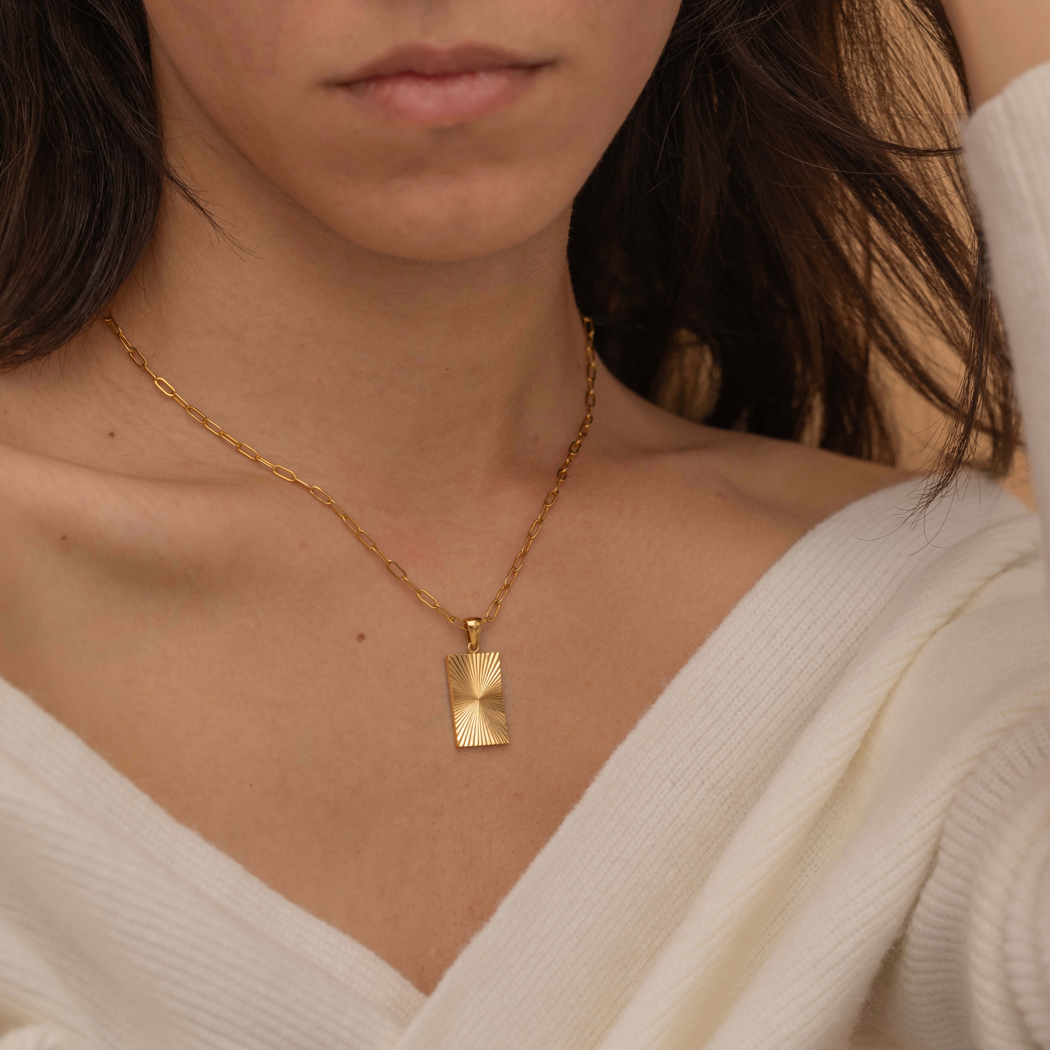 rectangle sunburst necklace with an etched sunburst design on a rectangle pendant, symbolizing warmth and vitality, perfect for adding a touch of boho elegance.