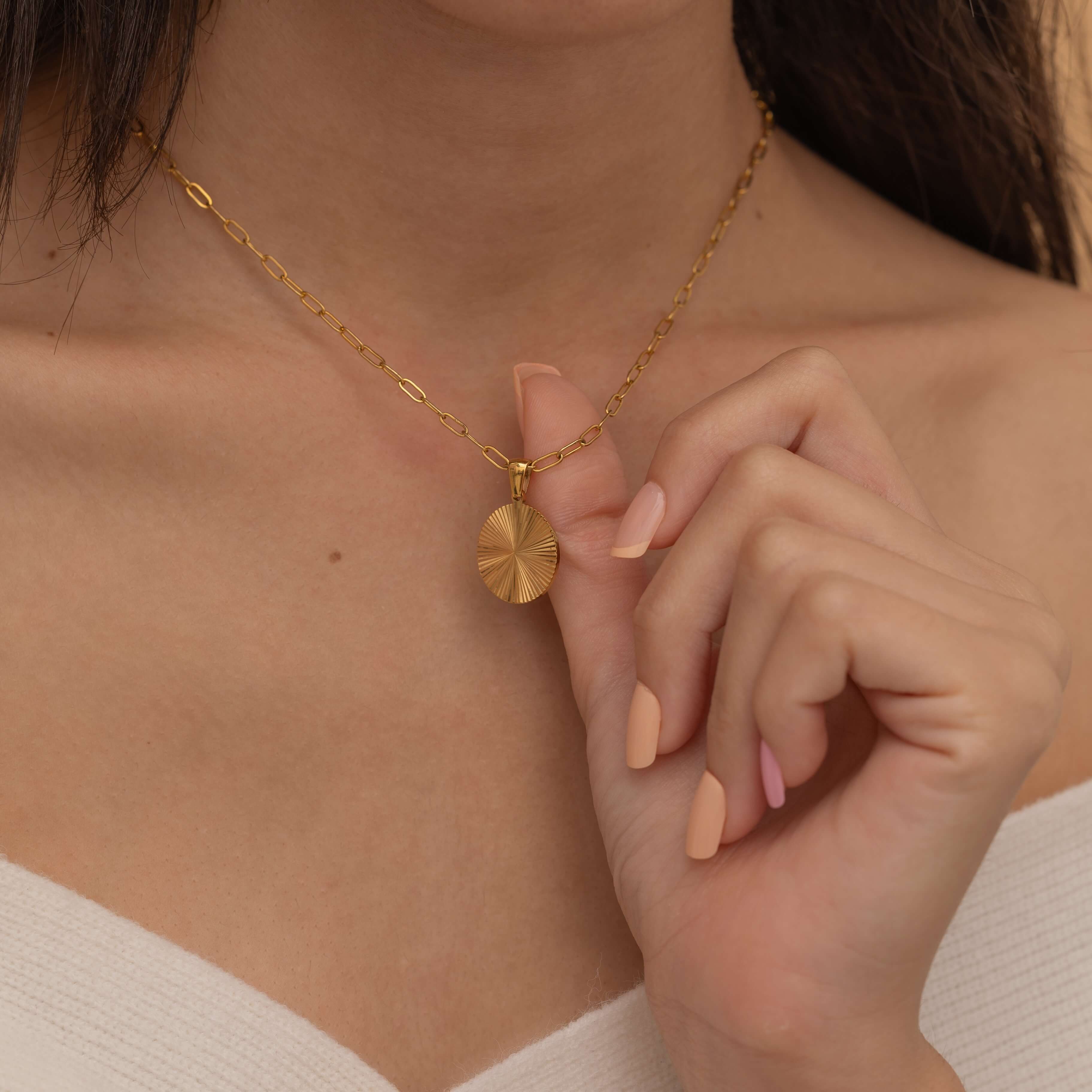 Circle sunburst necklace with an etched sunburst design on a round pendant, symbolizing warmth and vitality, perfect for adding a touch of boho elegance.