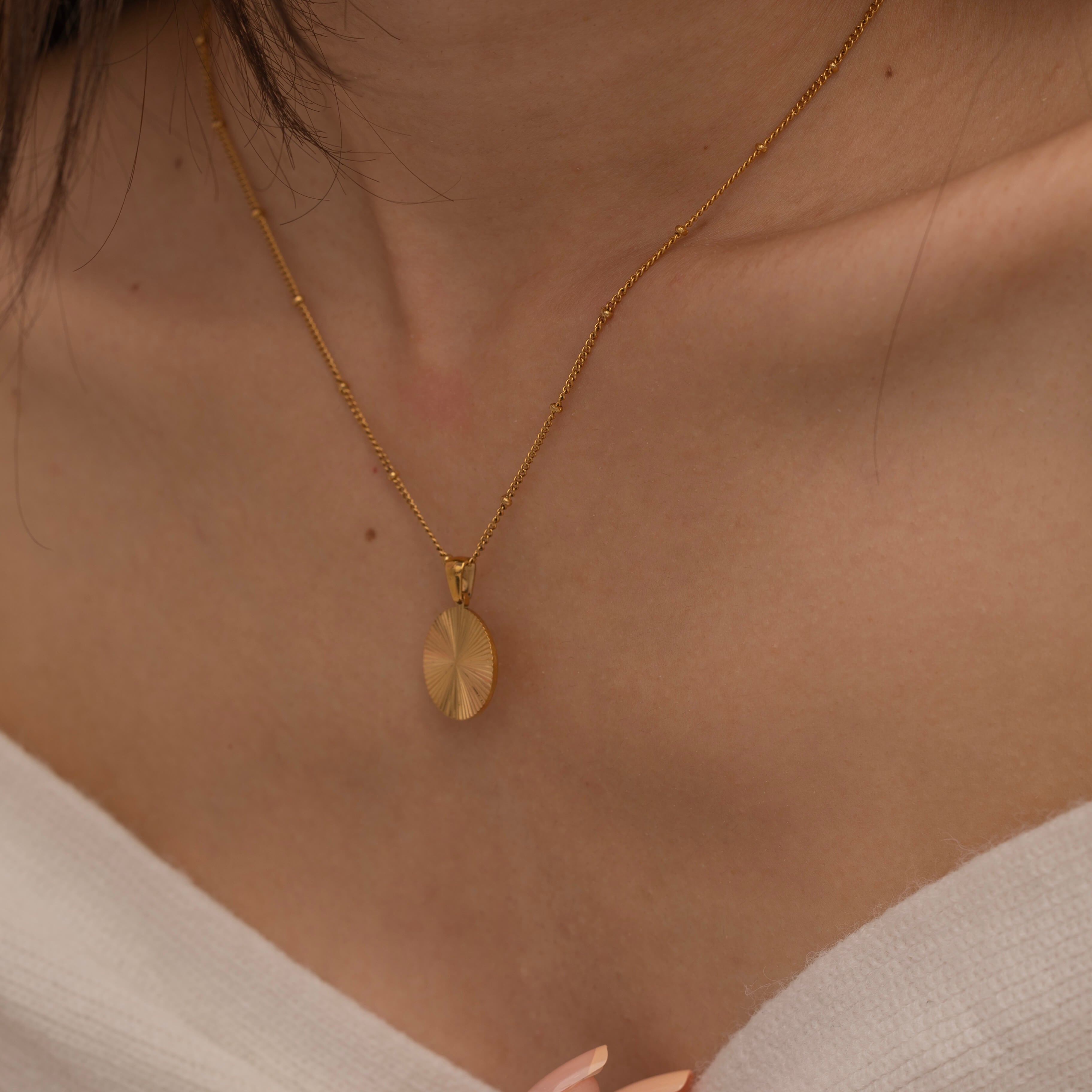 Circle sunburst necklace with an etched sunburst design on a round pendant, symbolizing warmth and vitality, perfect for adding a touch of boho elegance.