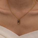 Gold magician tarot necklace with cubic zirconia accents and an onyx back stone, symbolizing the balance of elemental force.