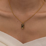 Gold magician tarot necklace with cubic zirconia accents and an onyx back stone, symbolizing the balance of elemental force.