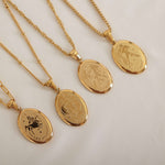 Gold zodiac pendant necklace on a dainty elongated link chain, featuring an engraved oval charm available in all zodiac signs for personalized style.