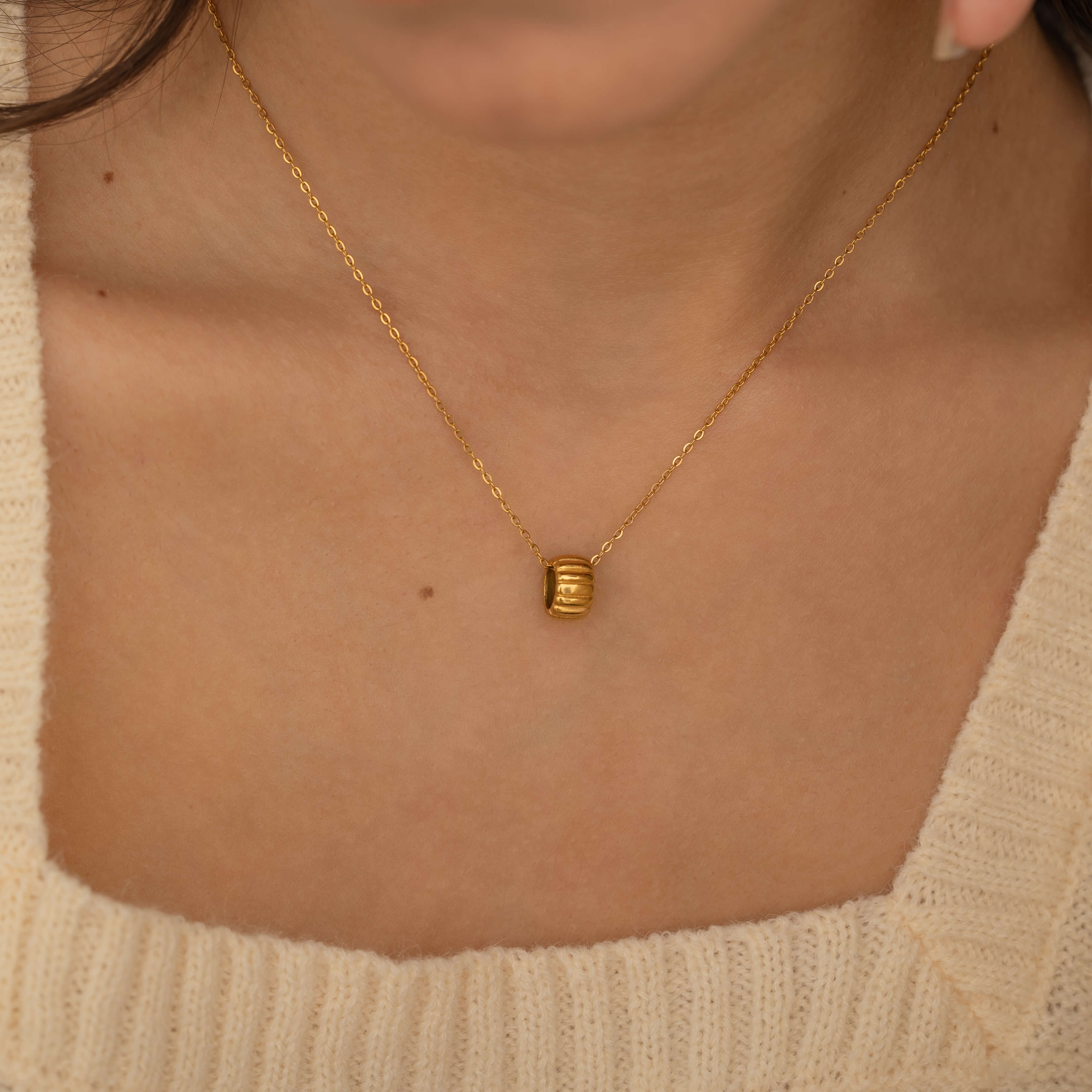 A close-up of the elegant Barrel Pendant Necklace with a gold chain, perfect for adding a touch of sophistication to any outfit from CHLOEVA