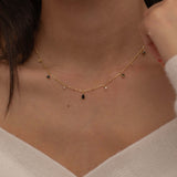 Dainty sterling silver and 14k gold plated necklace featuring four square black onyx birthstone stones, one centered teardrop-shaped onyx stone, and four white cubic zirconia accents between the onyx stones. Perfect for mother’s day and prom. 