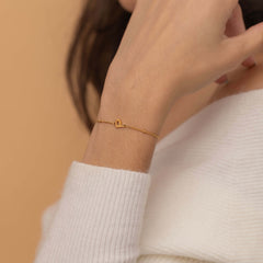 Single initial bracelet in silver, gold, or rose gold with a personalized charm on a delicate chain for a classic, customizable accessory.