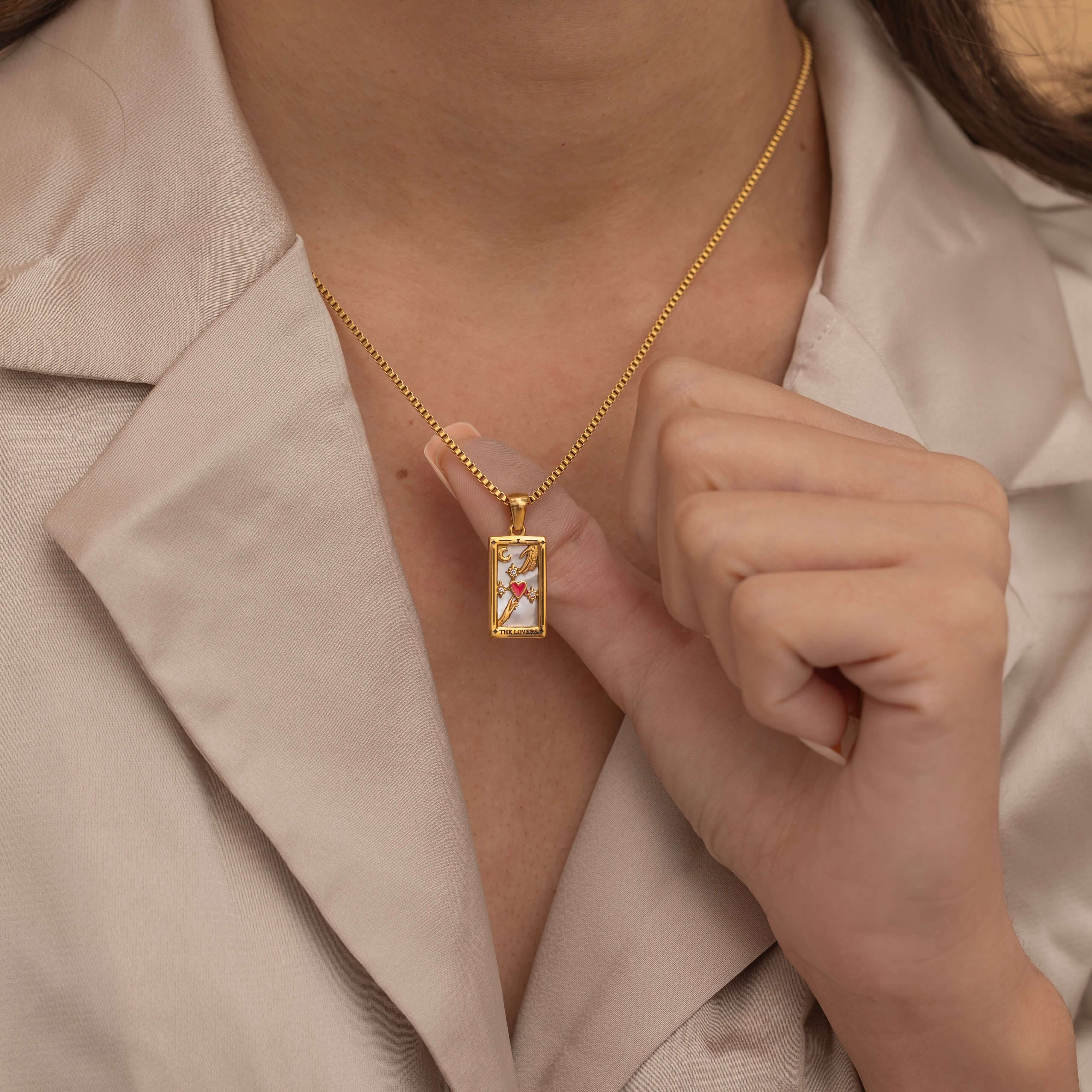 Gold the lovers tarot necklace with cubic zirconia accents and an mother of pearls back stone, symbolizing connection and unity