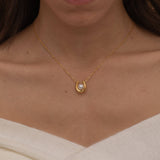 Gold U-shaped necklace with a single pearl centerpiece in the middle, creating a minimalist and elegant jewelry design.