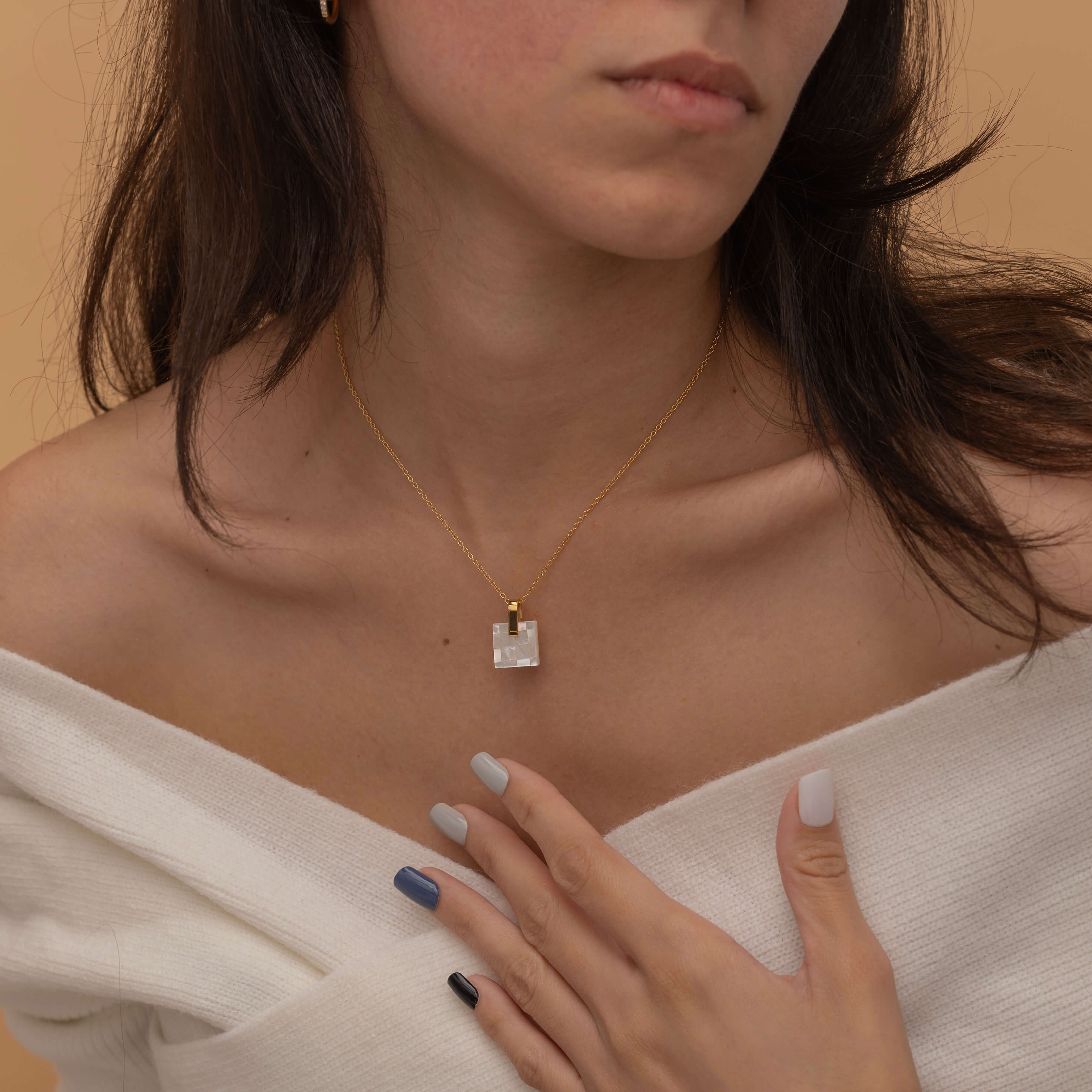 Square mother of pearl pendant with a soft iridescent finish, showcasing natural color variations and a minimalist design.