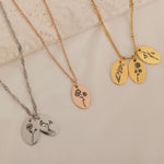 Close-up of a necklaces with multiple pendants, each engraved with a birth flower representing different family members.