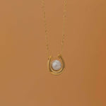 Gold U-shaped necklace with a single pearl centerpiece in the middle, creating a minimalist and elegant jewelry design.