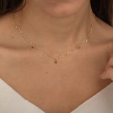 Dainty sterling silver and 14k gold plated necklace featuring four square peridot-colored cubic zirconia stones, one centered teardrop-shaped peridot stone, and four white cubic zirconia accents between the peridot.