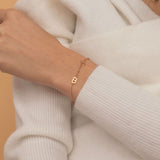 Custom bracelet with multiple initial charms in silver, gold, and rose gold, allowing for a personalized touch with multiple initials on one chain.