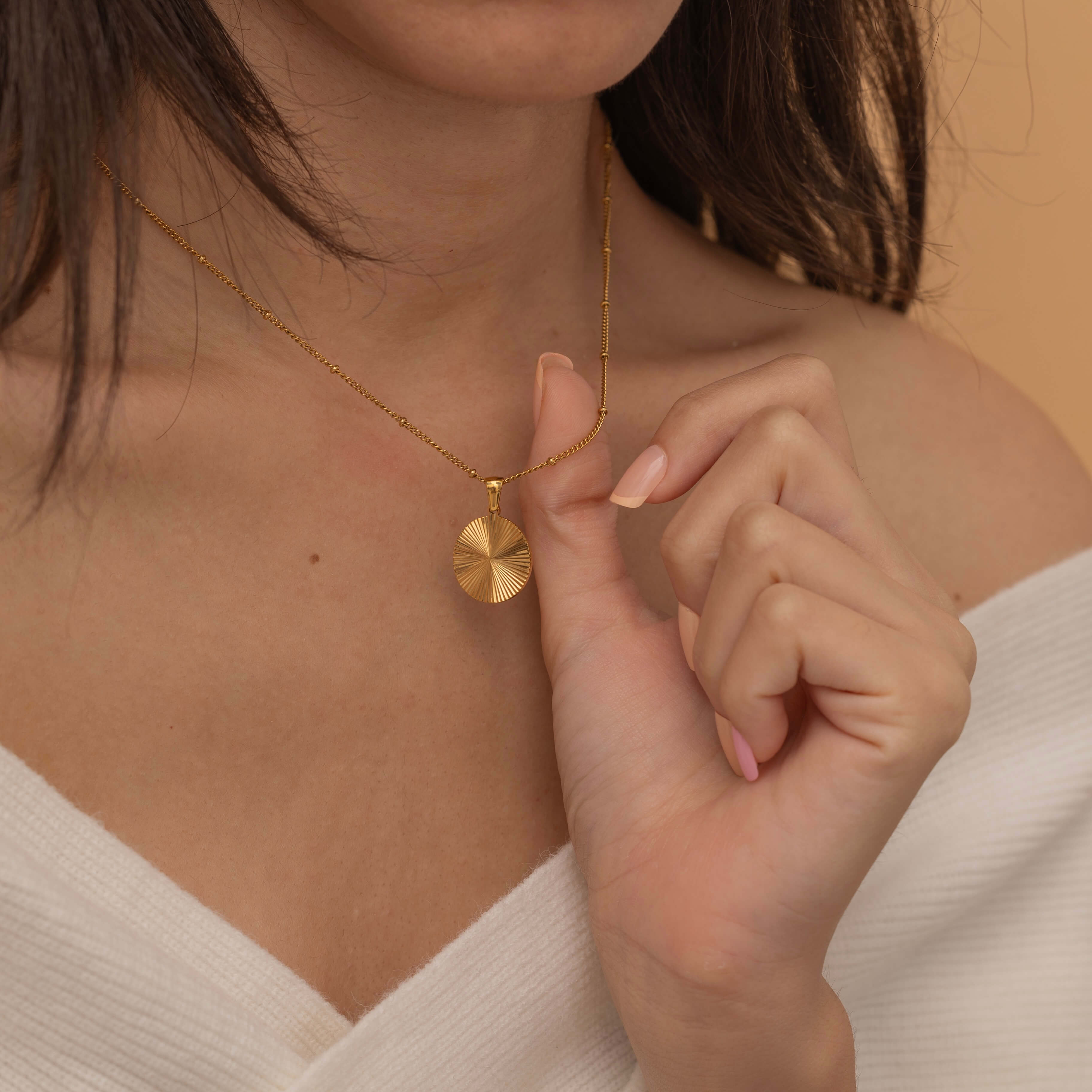 Circle sunburst necklace with an etched sunburst design on a round pendant, symbolizing warmth and vitality, perfect for adding a touch of boho elegance.