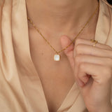 Square mother of pearl pendant with a gold frame on a gold chain