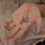 Silver and Gold the wheel tarot necklace with cubic zirconia accents and a mother of pearl back stone, symbolizing change, destiny, and the cycles of life. 