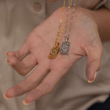 Silver and Gold the wheel tarot necklace with cubic zirconia accents and a mother of pearl back stone, symbolizing change, destiny, and the cycles of life. 
