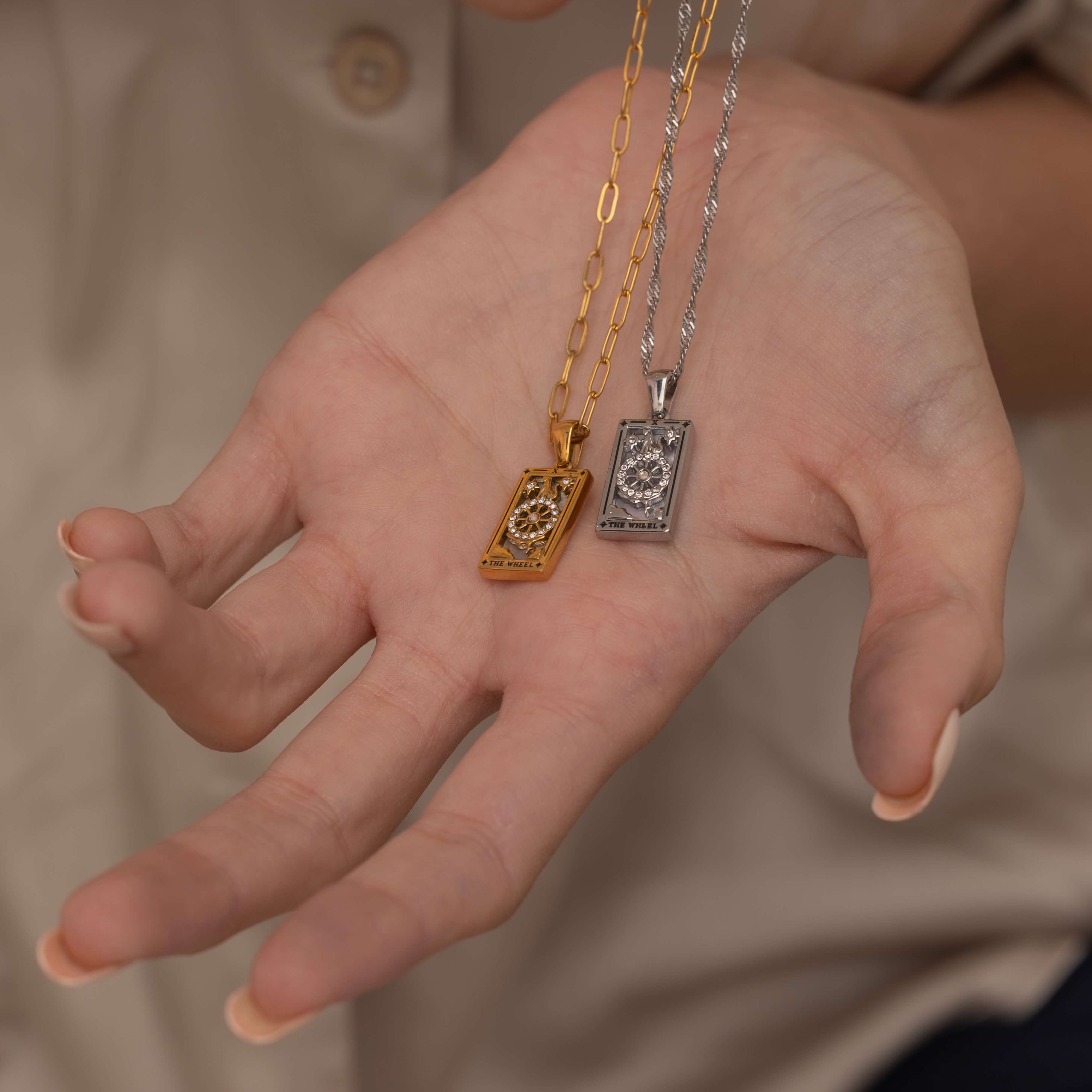 Silver and Gold the wheel tarot necklace with cubic zirconia accents and a mother of pearl back stone, symbolizing change, destiny, and the cycles of life. 
