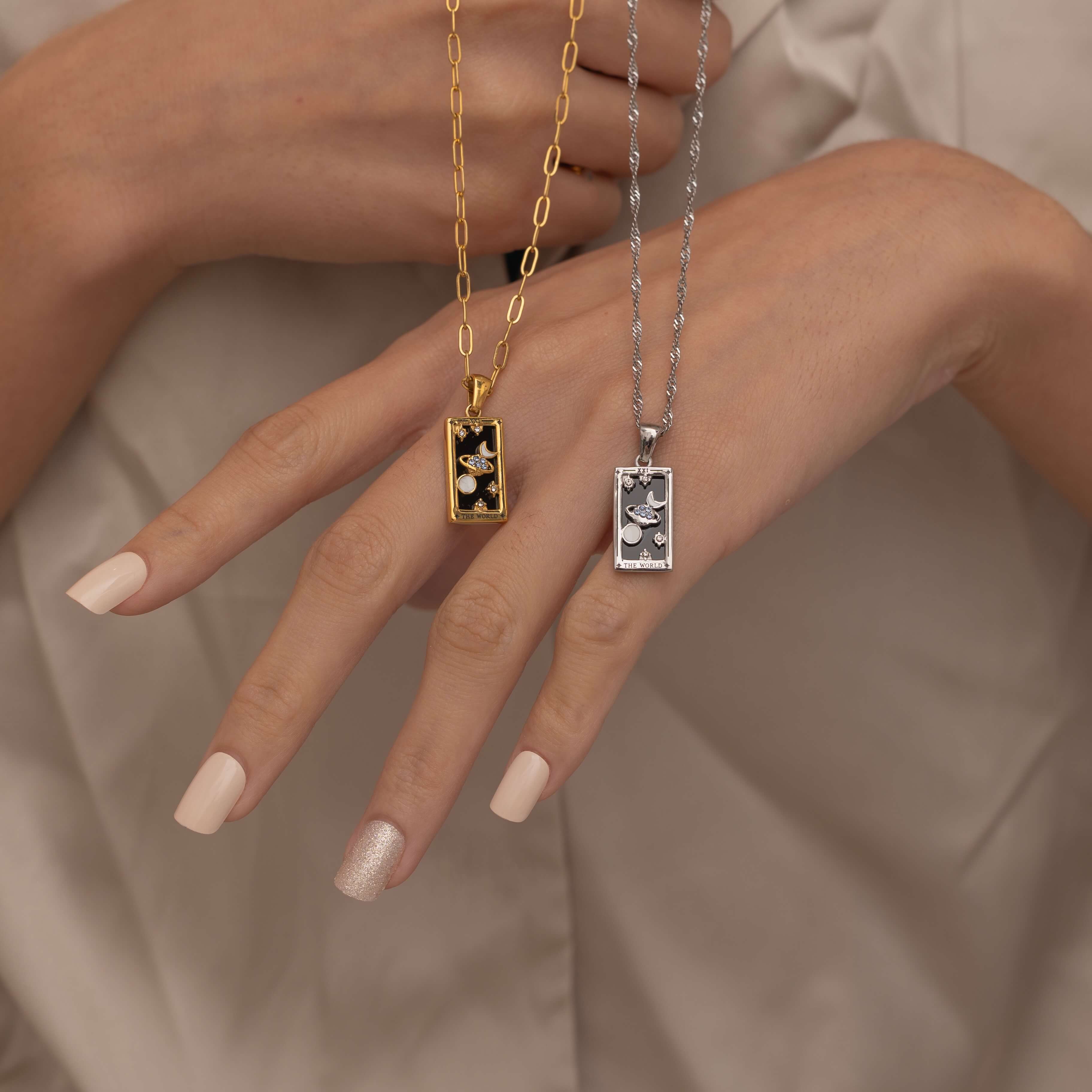 Silver and Gold the world tarot necklace with cubic zirconia accents and an black onyx back stone, symbolizing completion, unity, and the cyclical nature of life