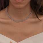 Elegant silver tennis necklace with a continuous row of sparkling, rectangular-cut stones. Perfectly aligned gemstones create a seamless shimmer, adding timeless sophistication to any look. Classic luxury jewelry piece ideal for formal occasions or adding everyday elegance.