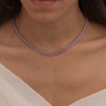 Elegant silver tennis necklace with a continuous row of sparkling, rectangular-cut stones. Perfectly aligned pink gemstones create a seamless shimmer, adding timeless sophistication to any look. Classic luxury jewelry piece ideal for formal occasions or adding everyday elegance.